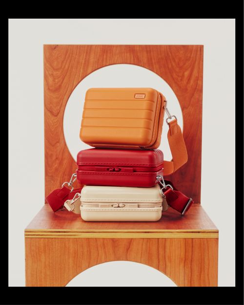 Away, luggage brand,. orange, red and tan sitting on a table. from the blog: Away: How Instagram's Favorite Luggage Brand Packed a Marketing Punch by sociallysavvymoms.com