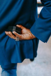 photograph of a person s hand holding a ring box