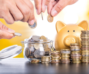 money management—hands of man and woman putting money in a piggy bank