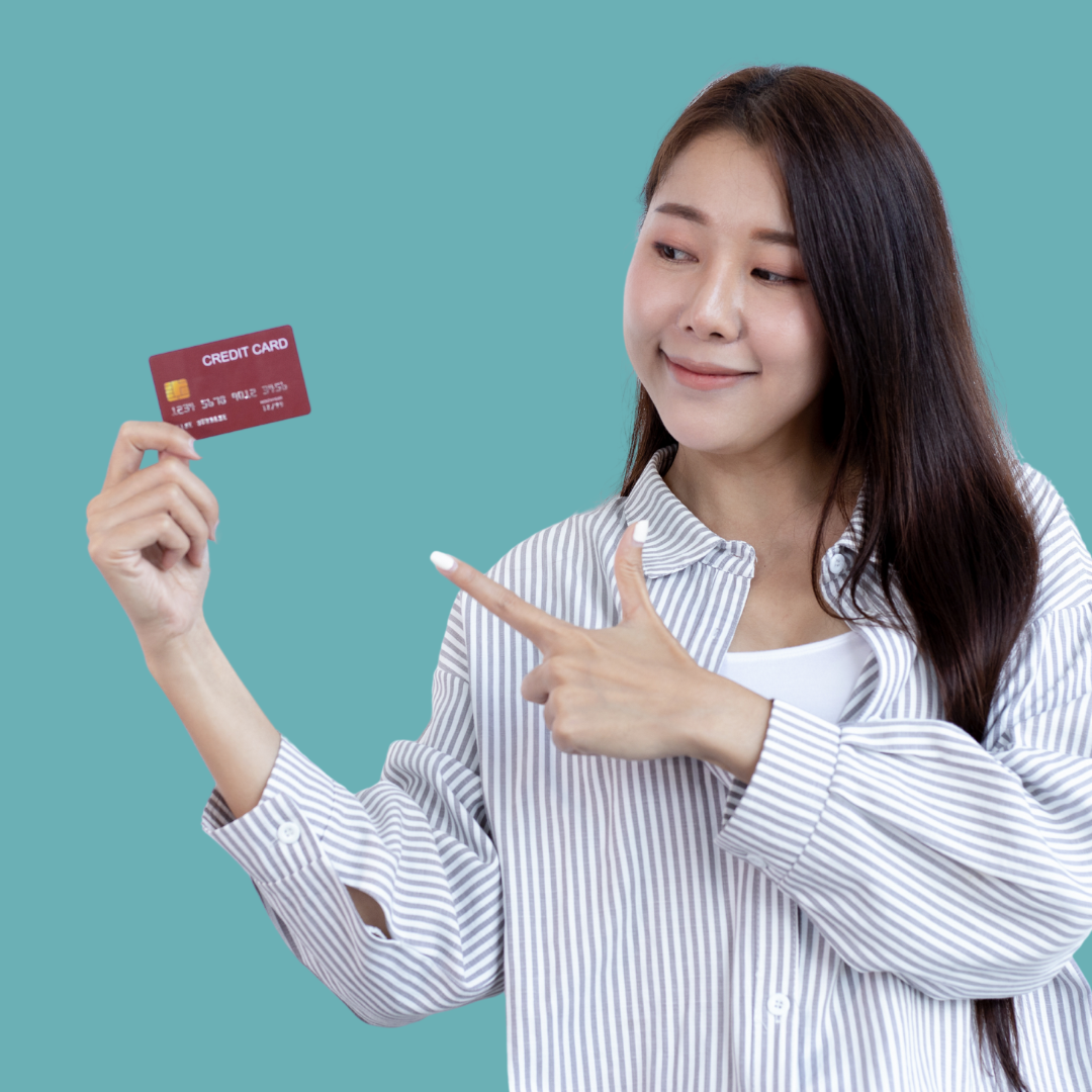 A young Asian woman holding a credit card in her hand