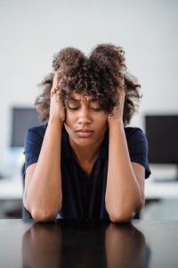 tired woman with hands in hair